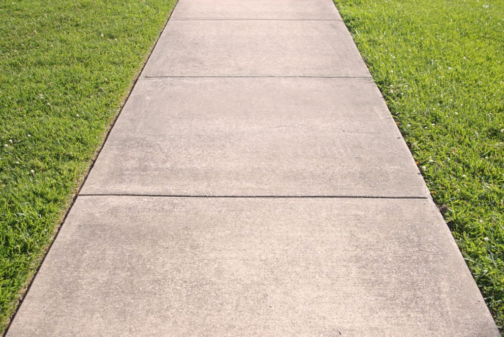 Detail of a concrete sidewalk with grass on both sides