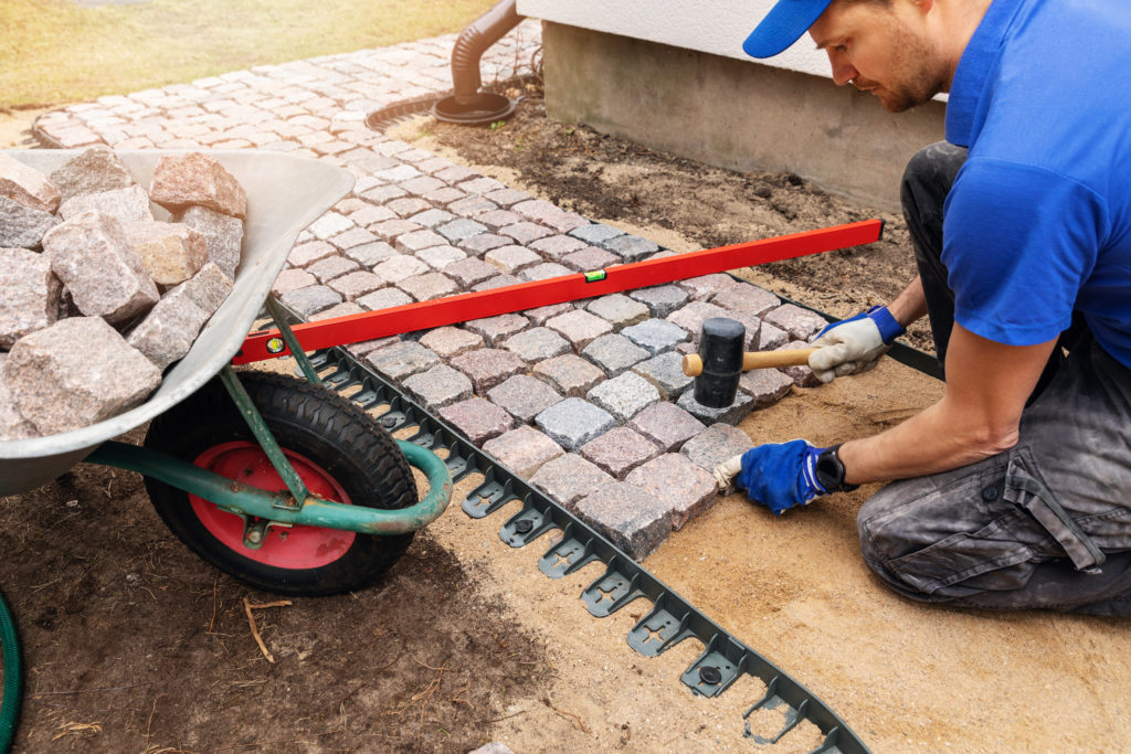 a do it yourselfer adding a stone walkway in his backyard