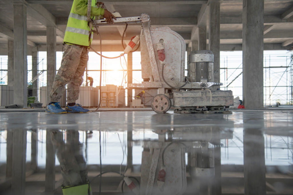 A person polishing commercial concrete in a warehouse in New Mexico.
