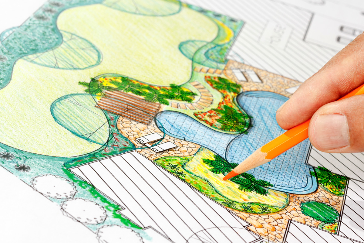 A person sketching a landscaping plan with an orange colored pencil in Hobbs.